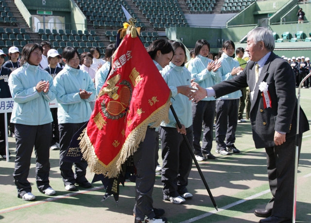 1_9416.JPG - 表彰式で優勝旗を受け取る園田学園の選手ら（福岡市博多区の博多の森テニス競技場で）